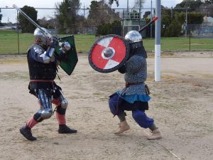 people in armor with shields fighting